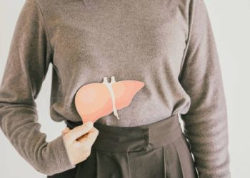 Woman holding liver illustration over abdomen indicating hepatitis complications