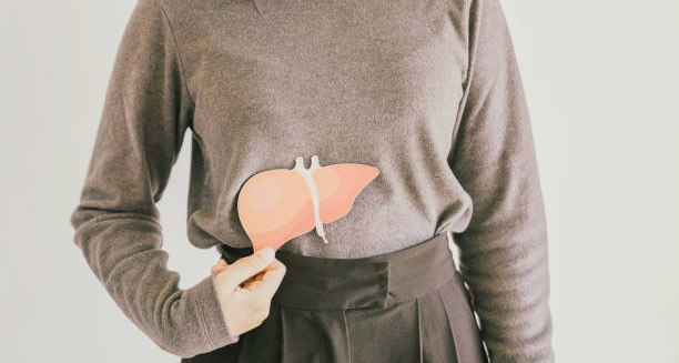 Woman holding liver illustration over abdomen indicating hepatitis complications