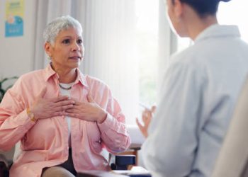 Concerned senior woman describing chest discomfort during consultation with healthcare provider
