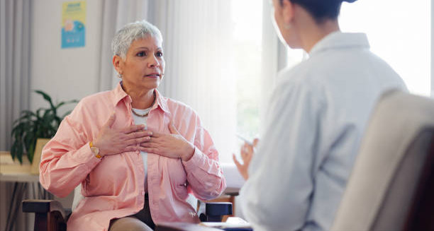 Concerned senior woman describing chest discomfort during consultation with healthcare provider