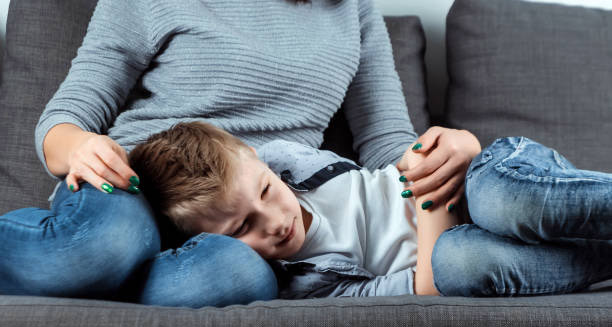 Unwell child lying on mother’s lap, illustrating complications of Hirschsprung’s disease