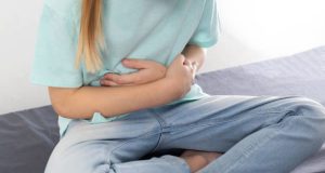 Child clutching stomach due to abdominal pain caused by hookworm complications