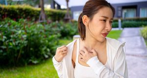 Woman scratching irritated skin on chest due to insect bite reaction
