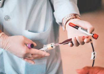 Medical professional holding blood vials and transfusion equipment for anaemia-related treatment
