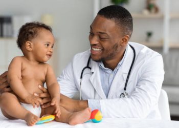 Doctor examining baby for signs of flat head syndrome