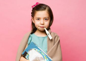 Sick girl with thermometer and tissues indicating flu diagnosis