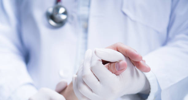 Doctor examining a patient’s hand for signs of frostbite