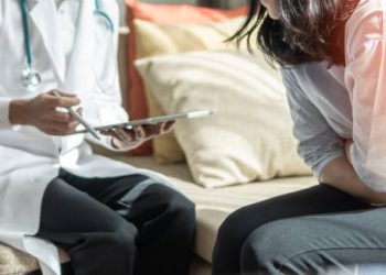 Doctor consulting a woman with abdominal pain