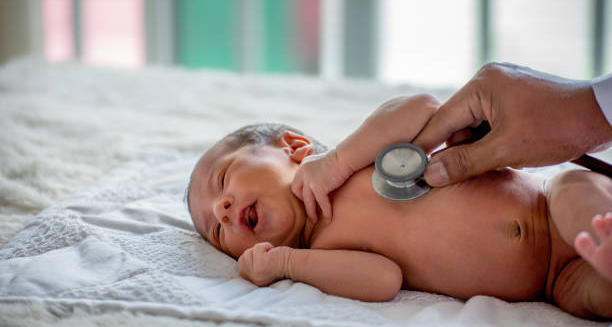 Doctor examining newborn baby with a stethoscope