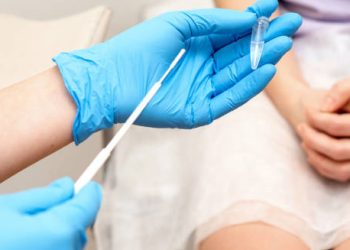 Medical professional holding a swab and sample tube for STI testing