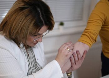 Doctor examining a patient's arm for grazes or skin injuries