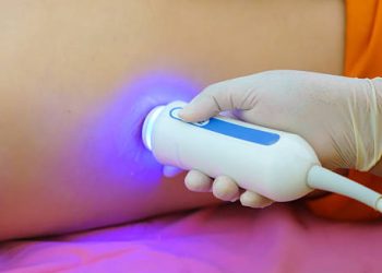 Ultrasound scan being performed on patient's side for haemochromatosis diagnosis