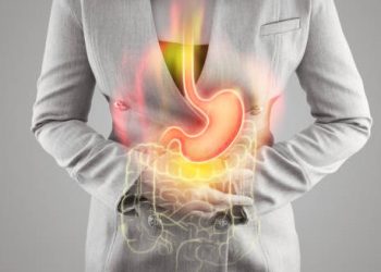 Illustration of stomach acid and digestive system overlayed on a person holding their abdomen