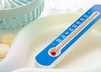 Thermometer reading high temperature beside medical cooling supplies