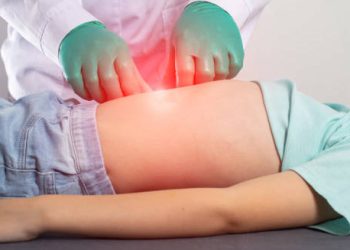 Doctor examining a child’s abdomen for signs of hernia