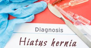Diagnosis form marked Hiatus Hernia beside medical tools and syringes