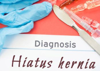 Diagnosis form marked Hiatus Hernia beside medical tools and syringes