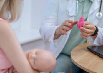 Paediatric doctor explaining diagnostic tools for Hirschsprung’s disease to mother with infant