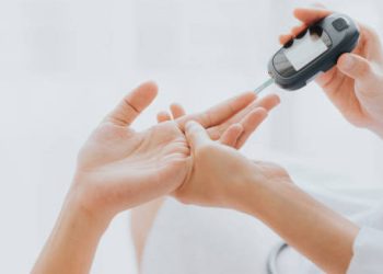 Blood glucose test being administered by a healthcare professional using a glucometer.