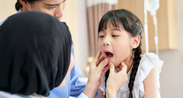 Paediatric doctor examining young girl's mouth and skin for impetigo symptoms