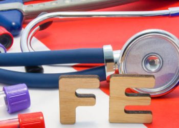 Stethoscope, test tubes, and wooden letters ‘Fe’ symbolising iron in blood tests for anaemia diagnosis
