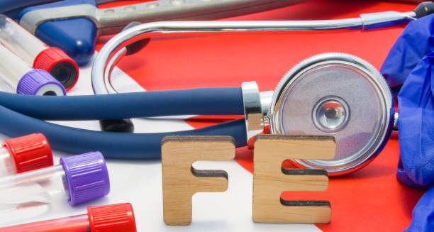 Stethoscope, test tubes, and wooden letters ‘Fe’ symbolising iron in blood tests for anaemia diagnosis
