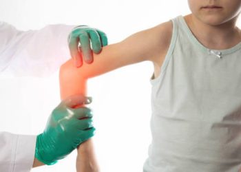 Doctor examining a child’s hypermobile elbow joint for signs of joint hypermobility syndrome