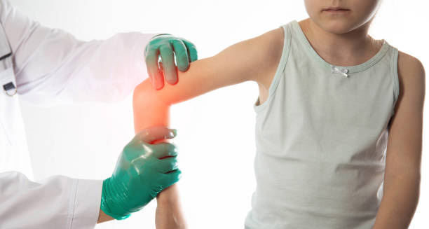 Doctor examining a child’s hypermobile elbow joint for signs of joint hypermobility syndrome