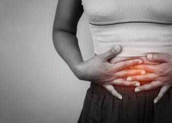 Woman clutching lower abdomen due to gastritis pain