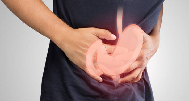 Person clutching stomach with illustrated digestive system overlay indicating stomach discomfort