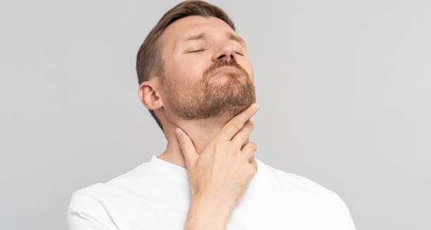 Man touching his throat with discomfort due to swollen glands