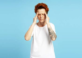 Woman experiencing discomfort from a possible hair dye reaction.