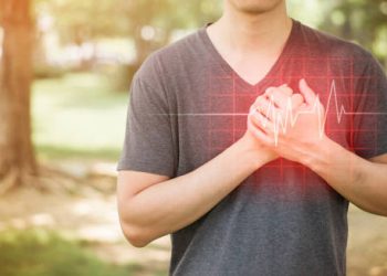Man clutching chest with digital heartbeat overlay, symbolising heart block symptoms