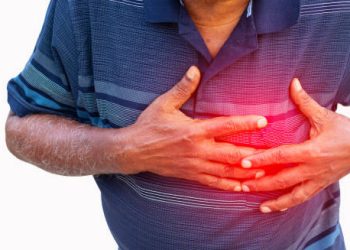 Man clutching his chest in pain with a red glow indicating heart disease symptoms