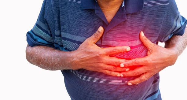 Man clutching his chest in pain with a red glow indicating heart disease symptoms