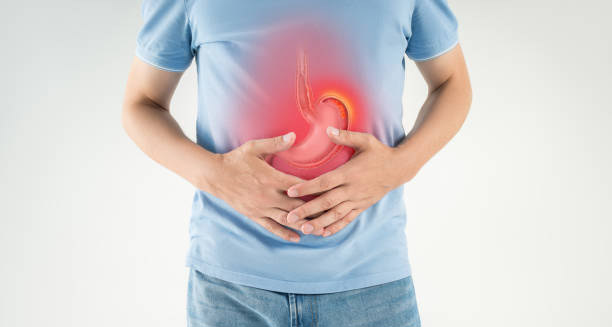Man holding stomach with red highlight showing heartburn discomfort