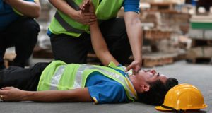 Worker receiving first aid after collapsing from heatstroke on site