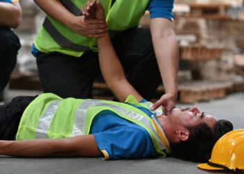 Worker receiving first aid after collapsing from heatstroke on site