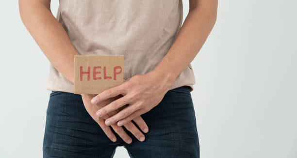 Man holding a cardboard sign with the word "HELP" in front of groin area