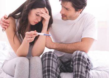 Couple distressed over negative pregnancy test result symbolising infertility