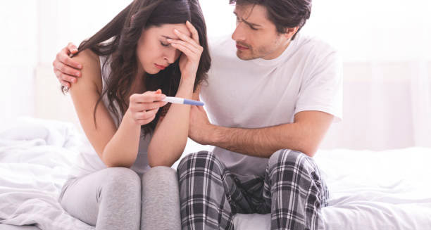 Couple distressed over negative pregnancy test result symbolising infertility