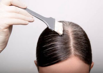 Hair dye being applied to scalp under careful supervision
