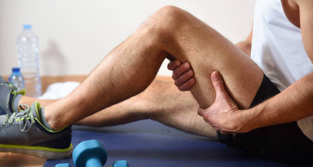 Man holding his hamstring during recovery from injury.