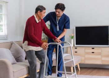 Nurse assisting elderly man with mobility, reflecting chronic Hepatitis B care