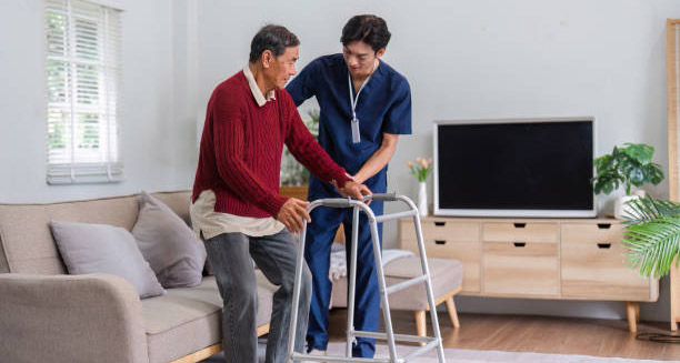 Nurse assisting elderly man with mobility, reflecting chronic Hepatitis B care
