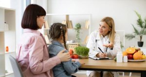 Doctor discussing long-term care and dietary guidance with a mother and daughter