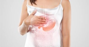 Woman holding chest with digestive illustration showing hiatus hernia condition