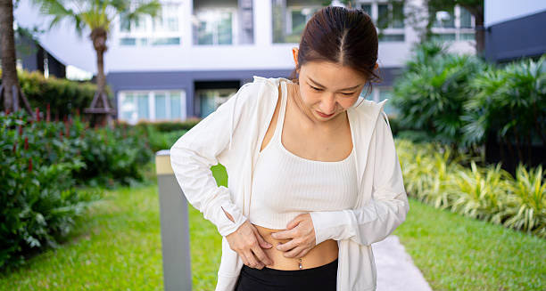 Young woman outdoors holding her side due to discomfort from hives