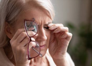 Elderly woman experiencing eye discomfort due to hypoparathyroidism