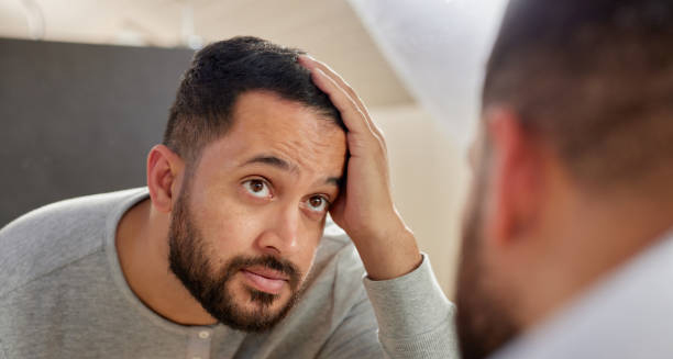 Man checking scalp in mirror to prevent hair dye reactions